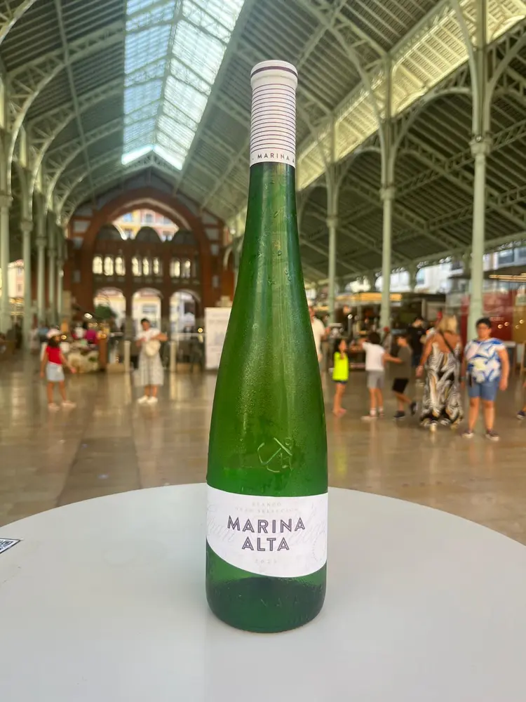 botella marina alta vino blanco con mercado de colón de fondo