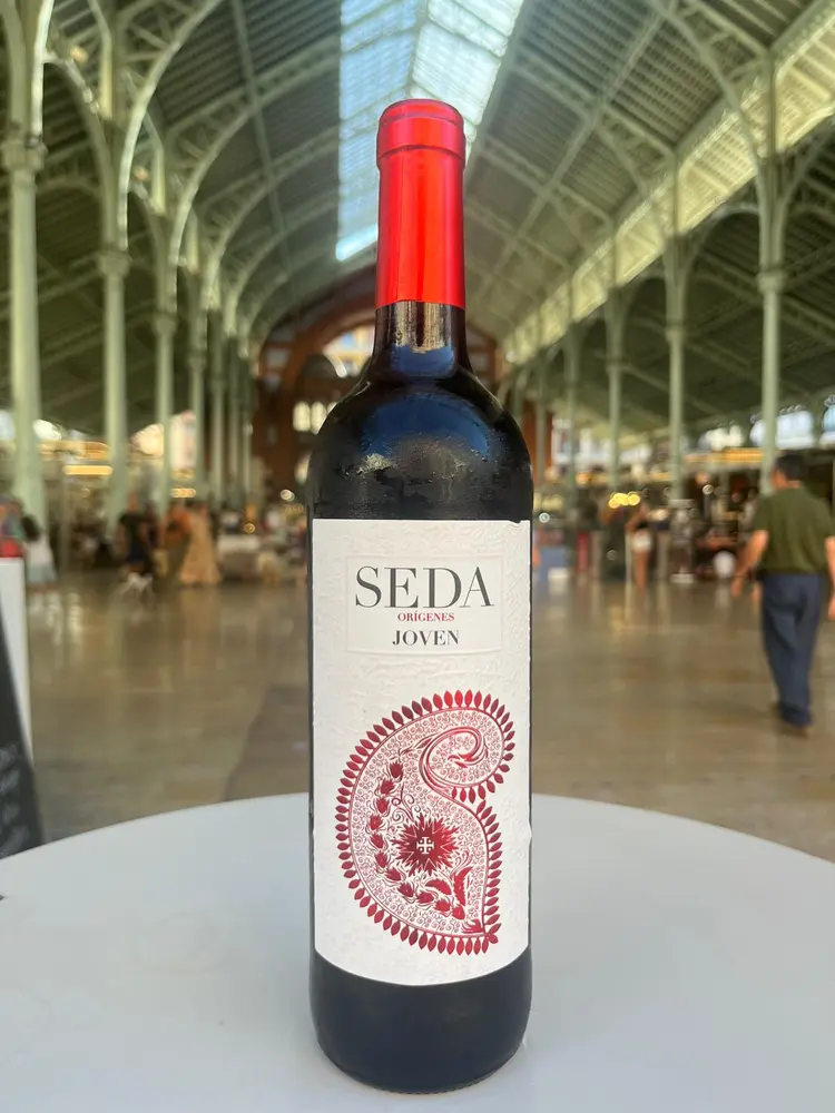 Vino tinto 'seda joven ' con el mercado de colón de fondo